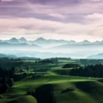 Aerial view of a golf course and mountains.