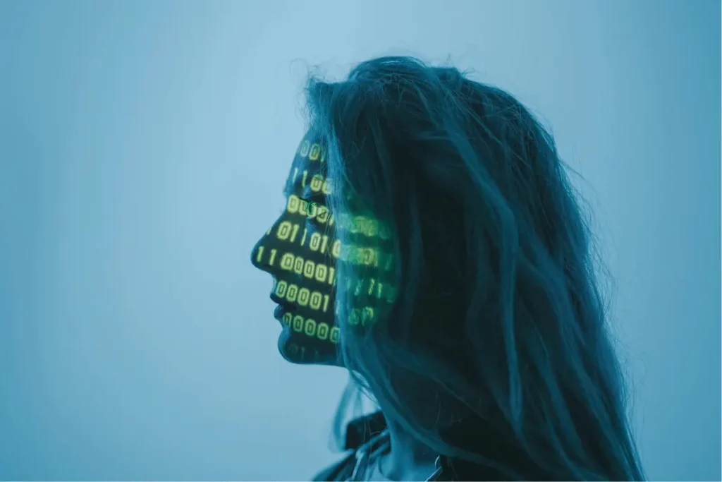 Silhouette of a woman's face with binary code projected onto it, against a blue background.