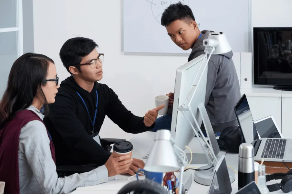 A group of people working on computers in an office.