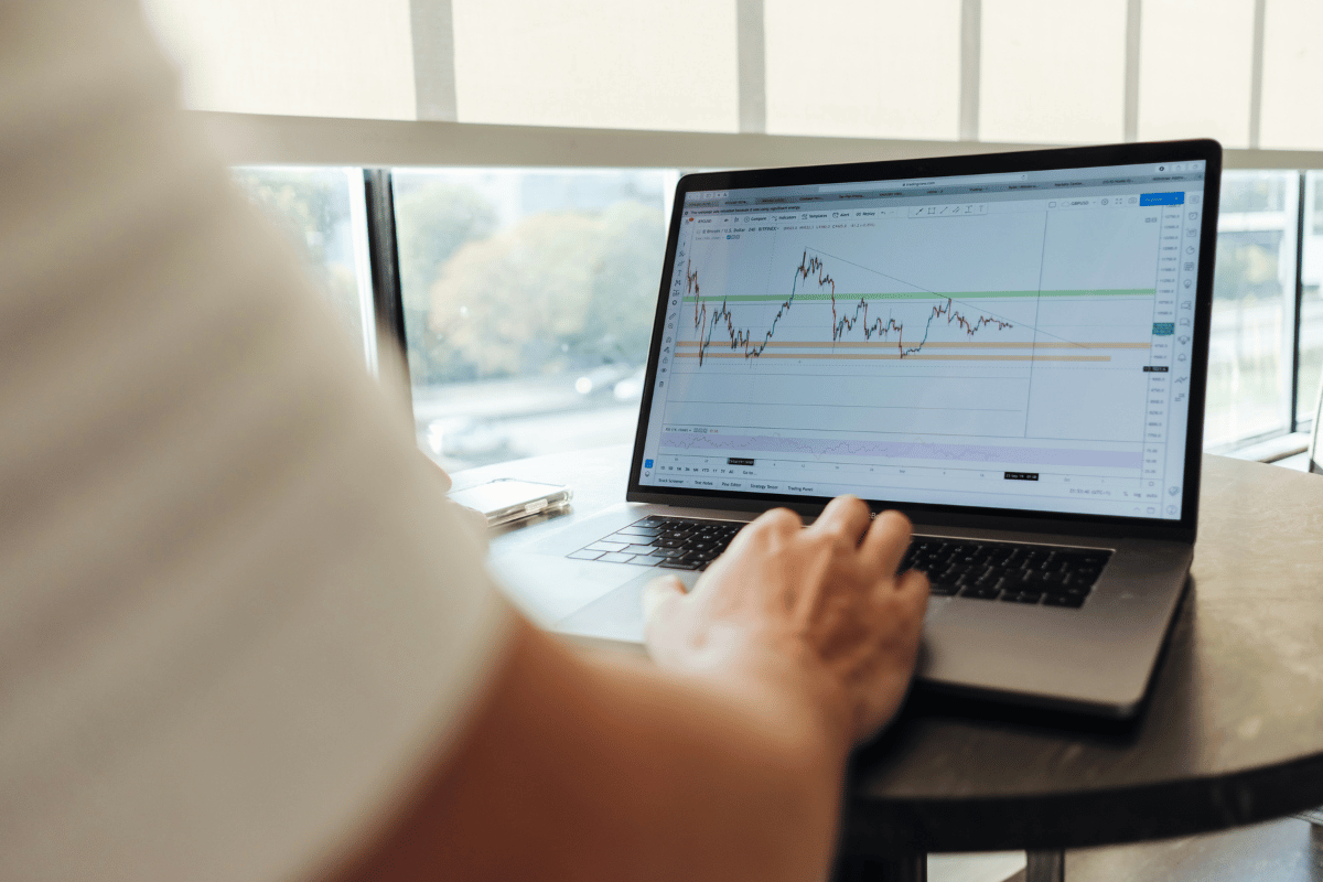 A person analyzing a graph on a laptop, focused on data interpretation and insights.