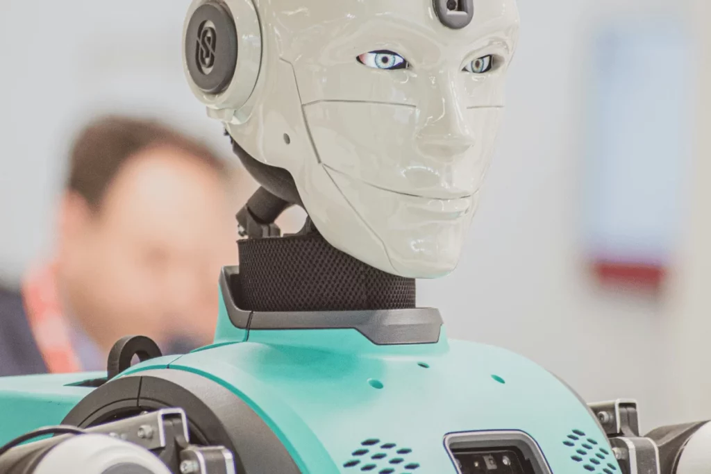 Close-up of a humanoid robot with a white face and teal body.