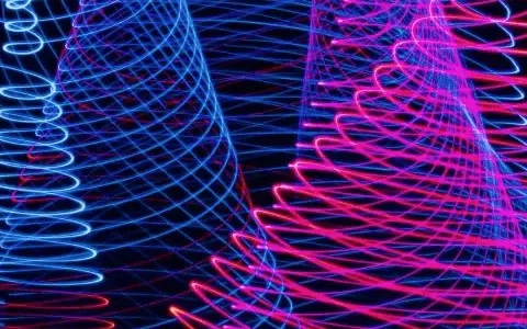 Abstract light patterns with swirling blue and pink neon lines on a black background.