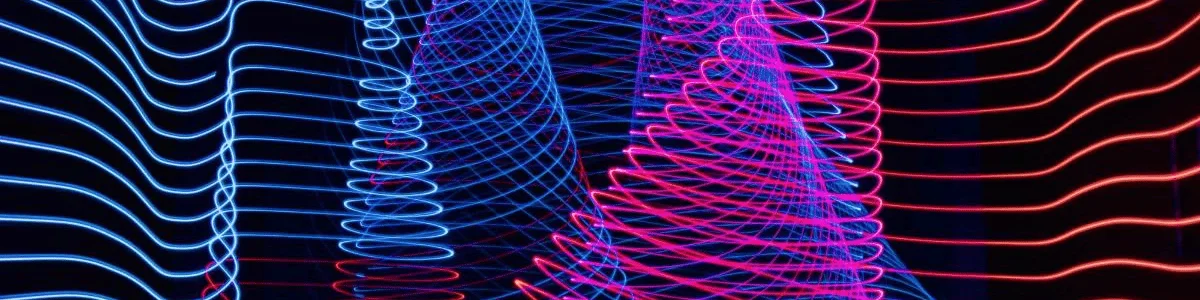 Abstract light patterns with swirling blue and pink neon lines on a black background.