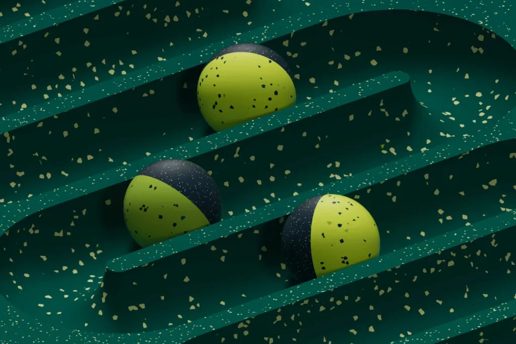 Abstract 3D balls resting in a curved maze-like green structure.