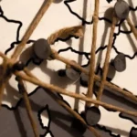 Abstract network of black lines and nodes with shadows on a light wall.