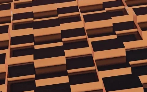 Abstract pattern of interlocking black and orange blocks creating a three-dimensional texture on a building facade.
