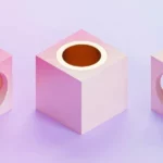 Three pastel-colored cubes with varying cutouts, showcasing golden spheres inside, set against a soft gradient background.
