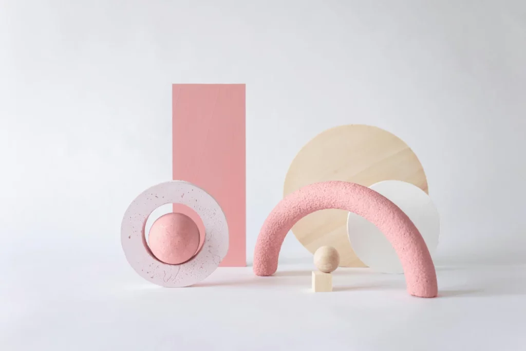 Modern sculptural art with soft pink and neutral geometric forms.