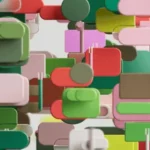 An abstract composition of colorful 3D shapes resembling blocks and circles in green, pink, red, and brown, creating a dynamic visual effect.