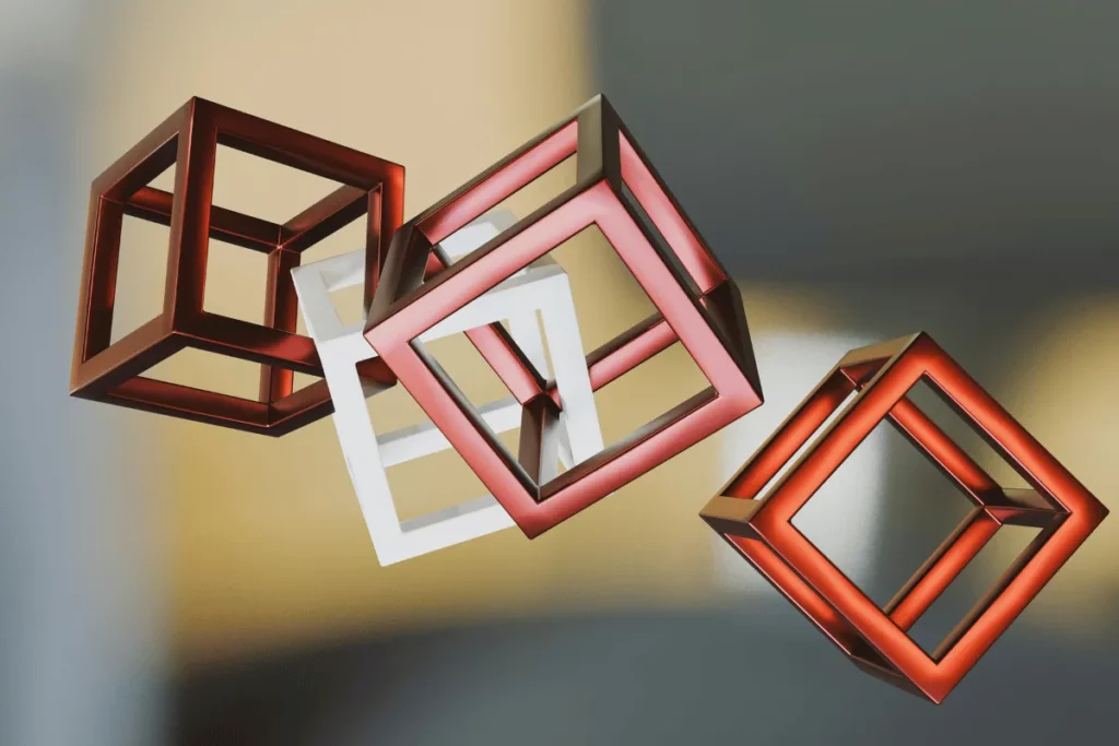 Four 3D geometric cubes in red, white, and silver, floating against a blurred background, showcasing depth and dimension.