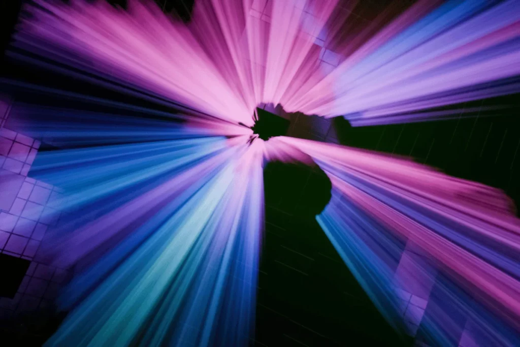 Abstract light beams in purple and blue radiating from the center, creating a burst effect.