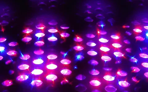 A close-up image of a textured surface illuminated with vibrant purple and blue lights, creating a mesmerizing, sparkling effect.