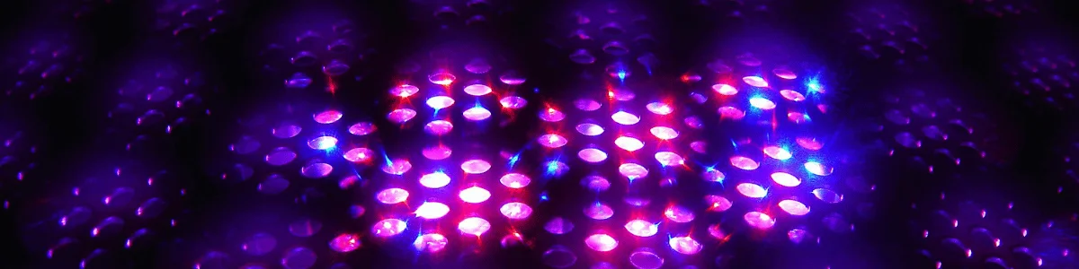 A close-up image of a textured surface illuminated with vibrant purple and blue lights, creating a mesmerizing, sparkling effect.