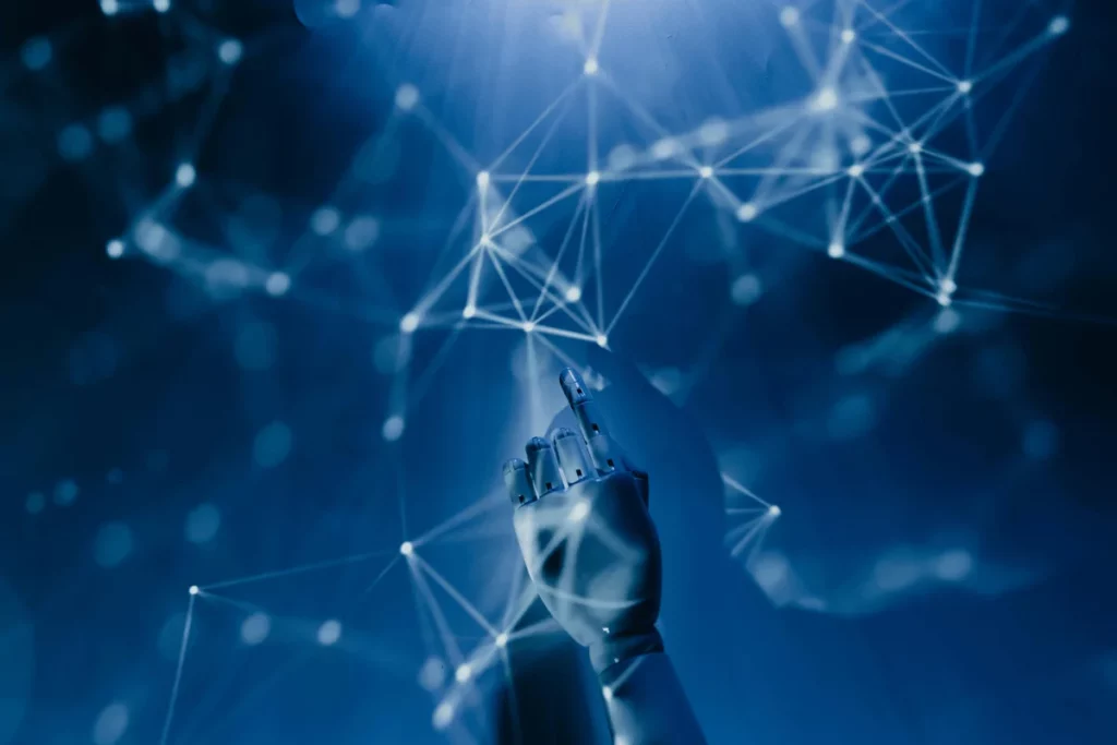 A futuristic robotic hand pointing upwards in a network of glowing lines and nodes against a blue background.