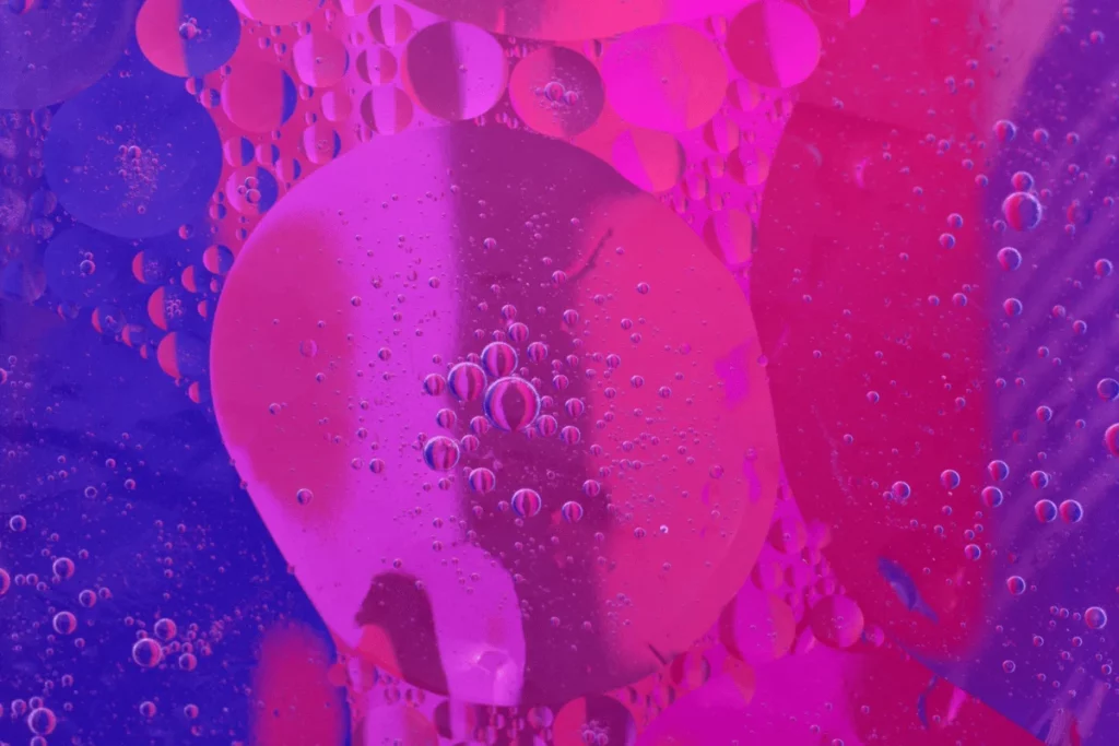 An artistic shot of overlapping bubbles in shades of pink and purple, creating a vibrant abstract composition.