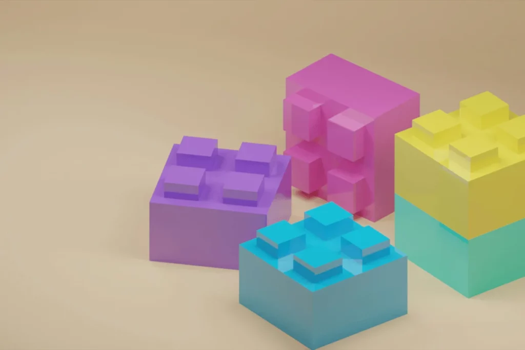 Colorful 3D building blocks in pink, purple, yellow, and blue stacked on a beige surface.