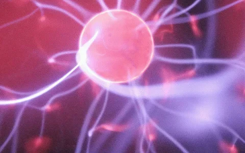 Close-up of an energy sphere surrounded by glowing electric filaments in purple and red hues. Abstract representation of electrical activity.