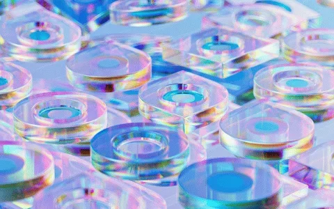 Close-up of various transparent, colorful geometric shapes with reflective surfaces, creating a vibrant, iridescent pattern.