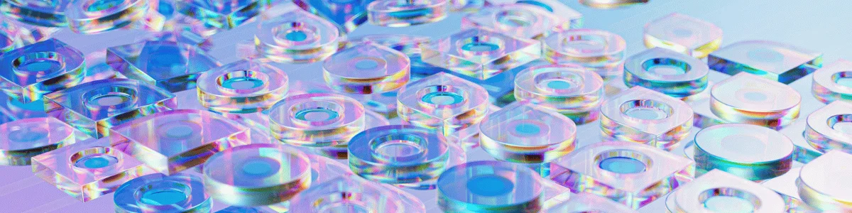 Close-up of various transparent, colorful geometric shapes with reflective surfaces, creating a vibrant, iridescent pattern.